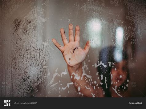 Muddy Hand Of Girl Pressed Up Against Glass Wall Of The Shower Stock