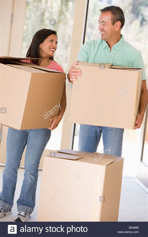 Couple With Boxes Moving Into New Home Smiling Stock Photo Alamy