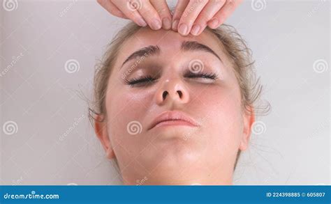 Facial Massage Beauty Treatment Close Up Of A Young Womans Face Lying On Back Getting Face