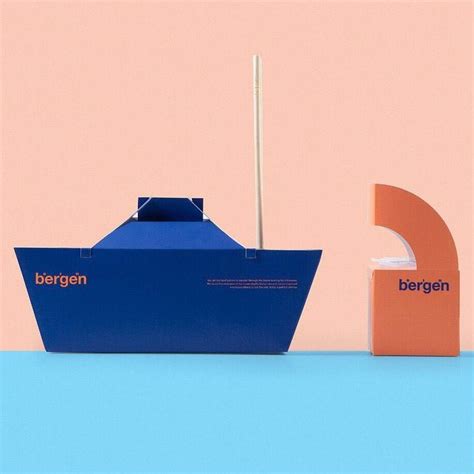 A Blue And Orange Boat Sitting On Top Of A Table Next To A Pink Wall
