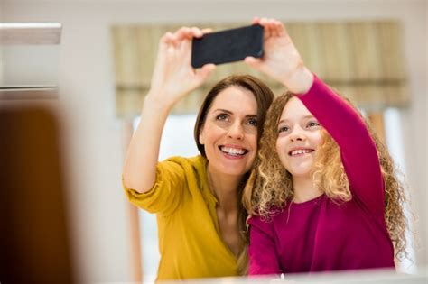 Free Photo Mother And Daughter Taking Selfie From Mobile Phone
