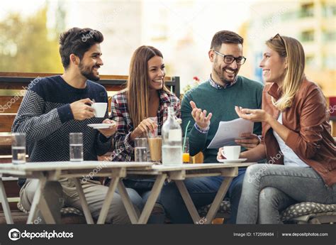 Group Of Four Friends Having Fun A Coffee Together Two Women An Stock