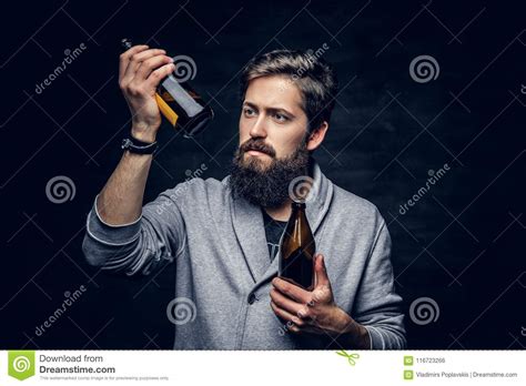 Bearded Male Looking On Two Craft Beer Bottles Stock Photo Image Of