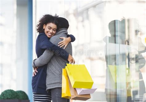 Young Lovers Hugging With Shopping Bags On The Street Stock Photo