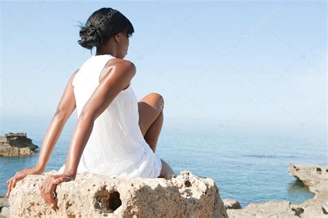 Black Woman Sitting Down On A Natural Rock Platform — Stock Photo