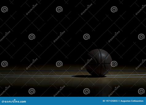 Basketball On Wooden Court Floor Close Up With Blurred Arena In