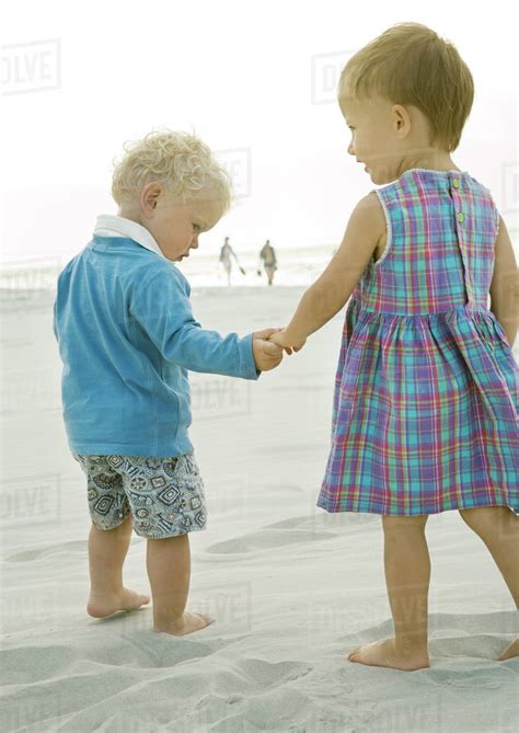 Two Toddlers Standing On Beach Rear View Stock Photo Dissolve