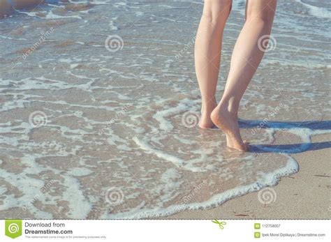 Close Up Of Woman Legs Walking Barefoot On Beach In Summer Holidays Vacation Concept Stock