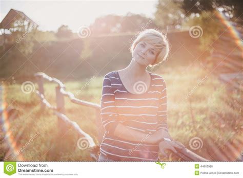 Young Woman At The Sunset Near Fence On The Country Background Stock