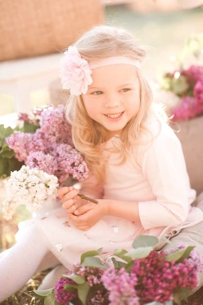 Premium Photo Smiling Baby Girl Holding Flowers Outdoors