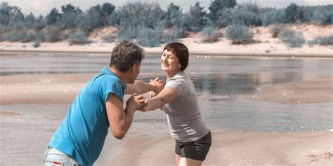 Beautiful Mature Sportive Couple Doing Gymnastic Exercises On The Beach