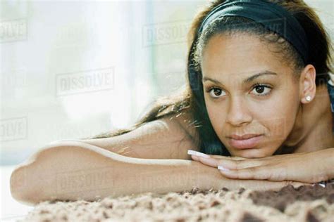 Mixed Race Woman Relaxing On Rug Stock Photo Dissolve