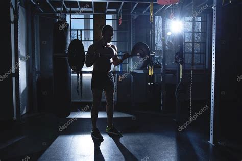 Muscular hombre atlético fuerte con el torso desnudo bombeando los músculos en el gimnasio