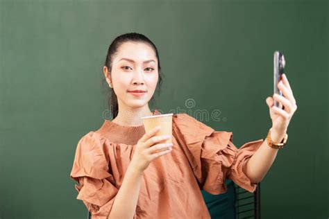 Beautiful Asian Woman Customer Looks At Right Side While Taking Selfie Shot With Takeaway Coffee