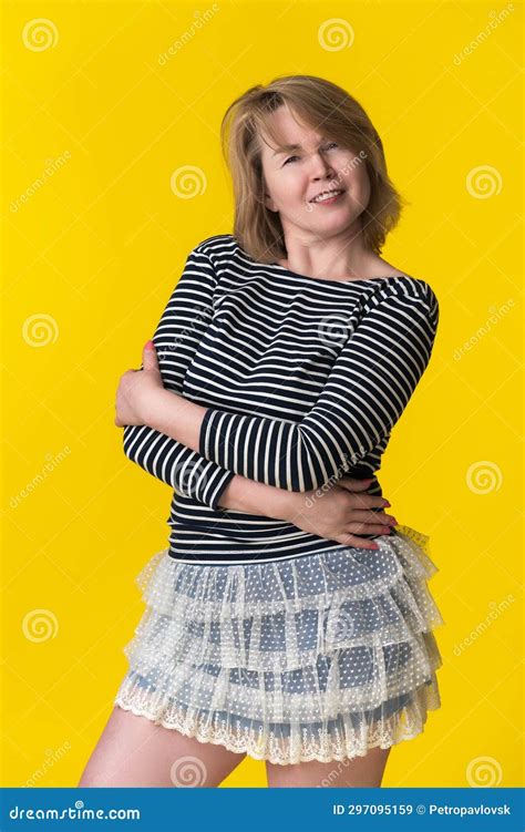 portrait curvy smiling woman mid adult blondie in long sleeve shirt and mini skirt with arms