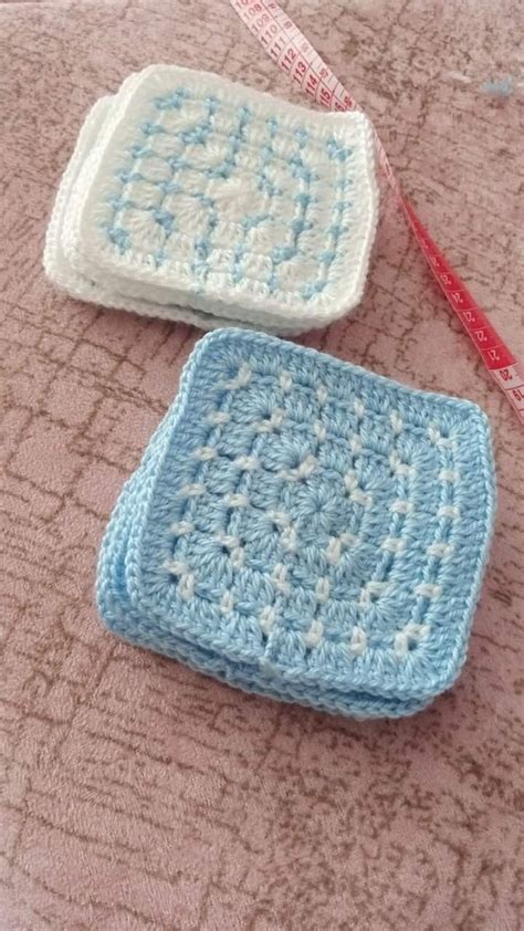 Two Crocheted Squares Sitting On Top Of A Bed Next To A Measuring Tape
