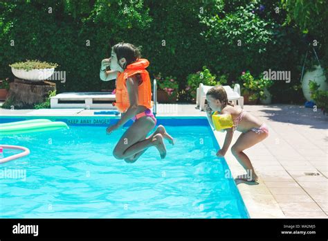 Deux petites filles sautant ensemble dans la piscine les émotions