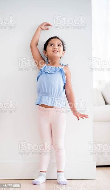 Girl Checking How Tall Shes Grown Stock Photo Download Image Now
