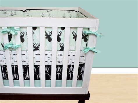 Fresh nursery with a white crib and rocking chair that sits on a gray round rug lighted by a spherical pendant light. Deer Crib Bedding Baby Boy Bedding Cribset Mint Black and