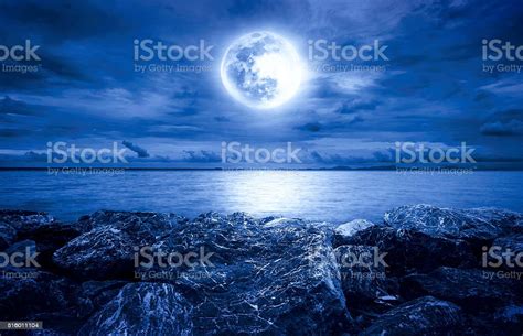 Full Moon Over The Ocean With Clouds And Rocks Stock Photo Download