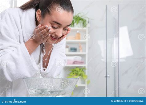 Beautiful Young Woman Washing Her Face With Water In Bathroom Space
