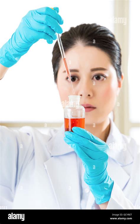 Asian Female Scientist Mixing Chemical Substances For Medical In