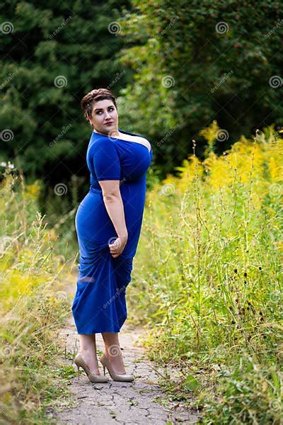 plus size model in blue dress with a deep neckline outdoors beautiful fat woman with big