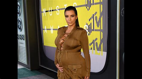 Kim Kardashian exibe barriga de grávida e decote generoso em look do