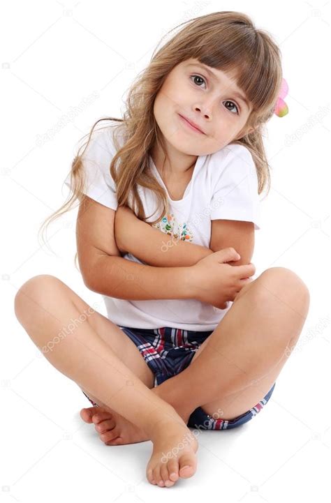 Kleines Mädchen sitzt isoliert auf weißem Boden Stockfoto