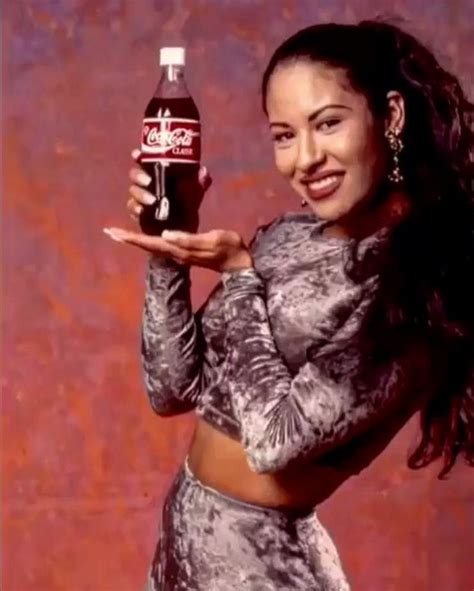 A Woman Holding Up A Coca Cola Bottle