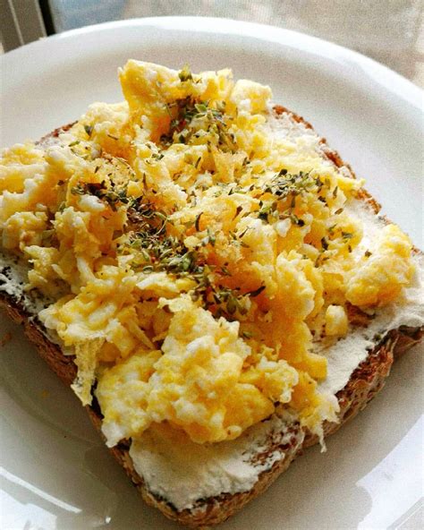 Tostada con pan integral queso crema huevo revuelto y orégano