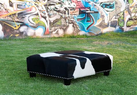 A Classic Black And White Cowhide Ottoman With Studs By Gorgeous