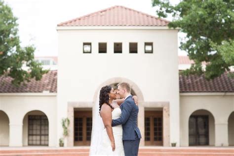 A Bride And Groom Kissing In Front Of A White Building With Red Tile