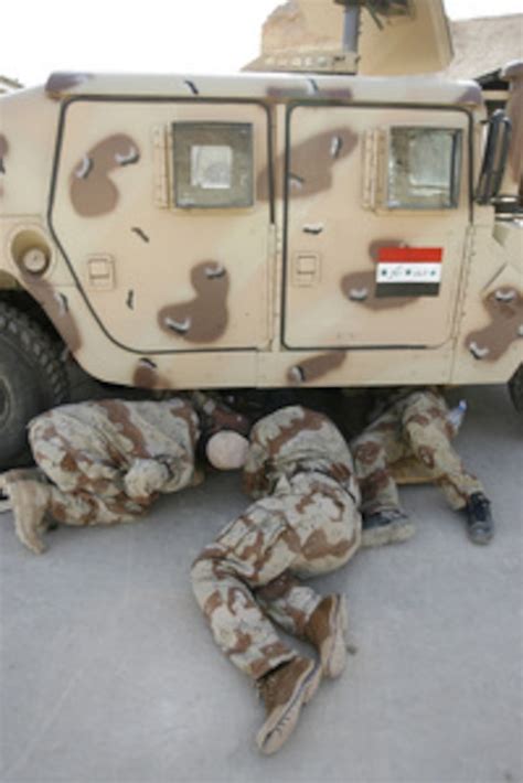 Iraqi Army Soldiers Examine The Underside Of A Humvee