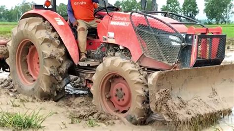 Kubota Tractor With Rotary Tiller Pushing And Tilling Muddy Field Youtube
