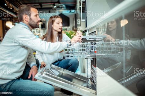 Husband And Wife Shopping For A New Dishwasher Model To A Young