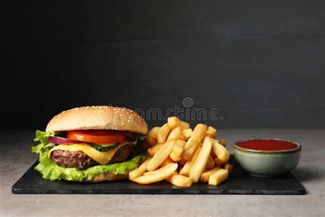 Delicious Burger Ketchup And French Fries Served On Grey Table Stock