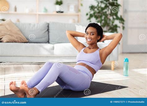 positive athletic black woman doing abs exercises during her home workout indoors stock image