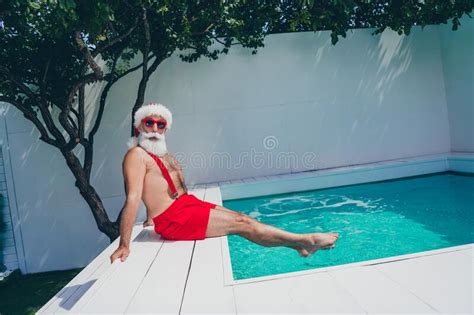 Photo Of Funny Impressed Santa Claus Wear Red Swimsuit Trying Cold Pool