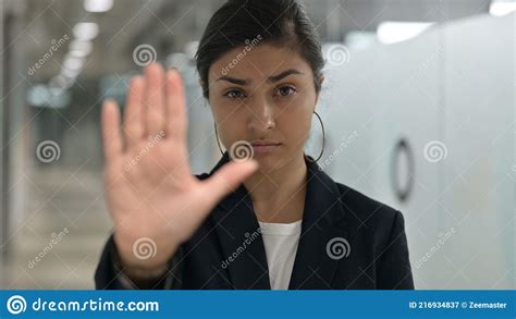 Portrait Of Serious Indian Businesswoman Showing Stop Sign By Hand