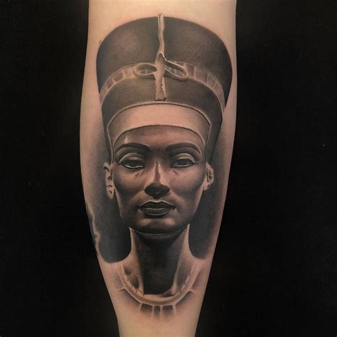 An Egyptian Woman S Tattoo On The Right Leg With Black And Grey Ink In It