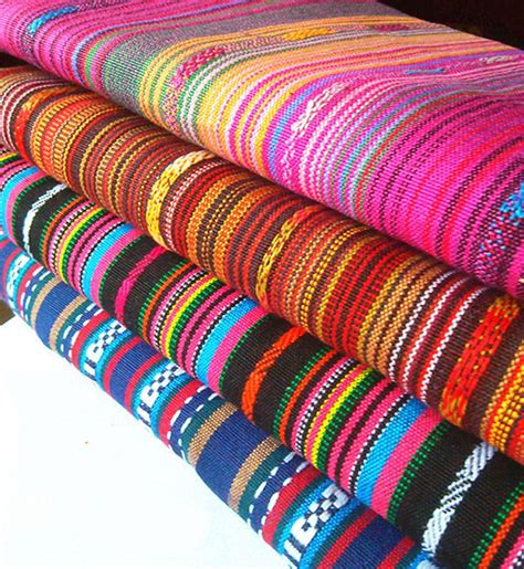 A Stack Of Multicolored Fabrics Sitting On Top Of A White Table Next To