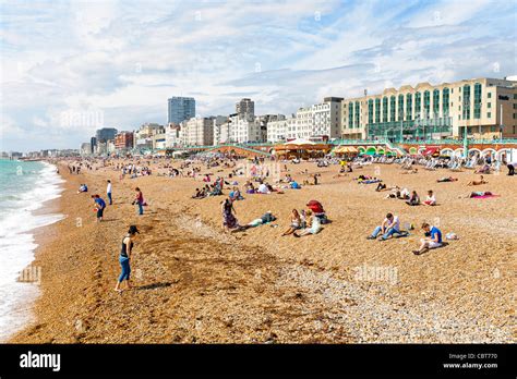 Sun Bathers And Swimmers Relaxing On The Ocean Beach In Brighton