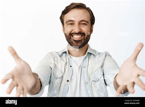 Portrait Of Happy Smiling Man With Beard Stretching Out Hands Reaching For Hug Hold Something