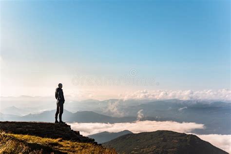 Man Standing At The Edge Of The Cliff Looking At Mountains Stock Image