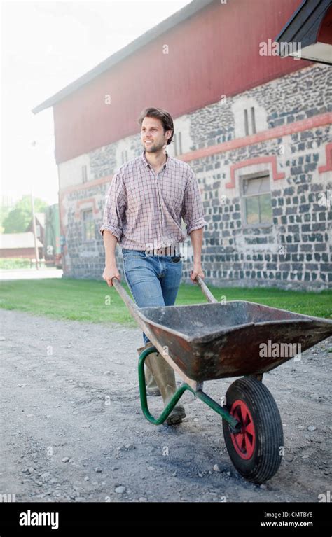 Man Pushing Wheelbarrow Stock Photo Alamy