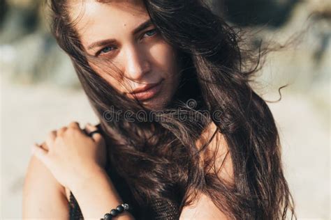 Portrait Of Brunette Model In Knitted Sweater Posing On The Sandy Beach