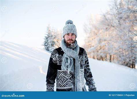Young Man Standing In Snow Nature Outdoors In Winter Looking At Camera