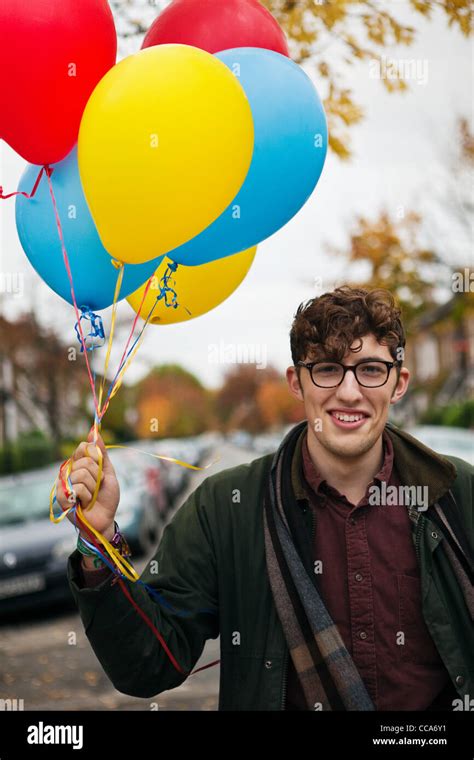 Young Man Holding Colourful Balloons Portrait Stock Photo Alamy