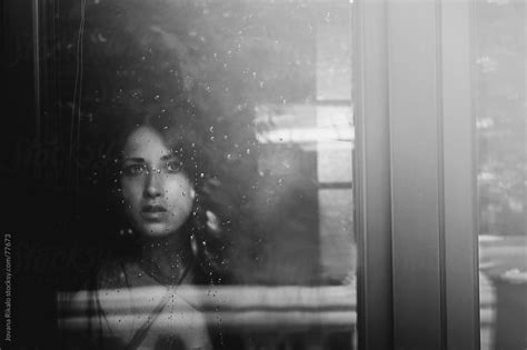 Beautiful Girl Standing At The Window Watching The Rain By Jovana